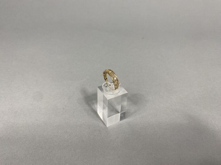 Bague en or jaune (375) à monture ajourée sertie de petites pierres blanches fa…