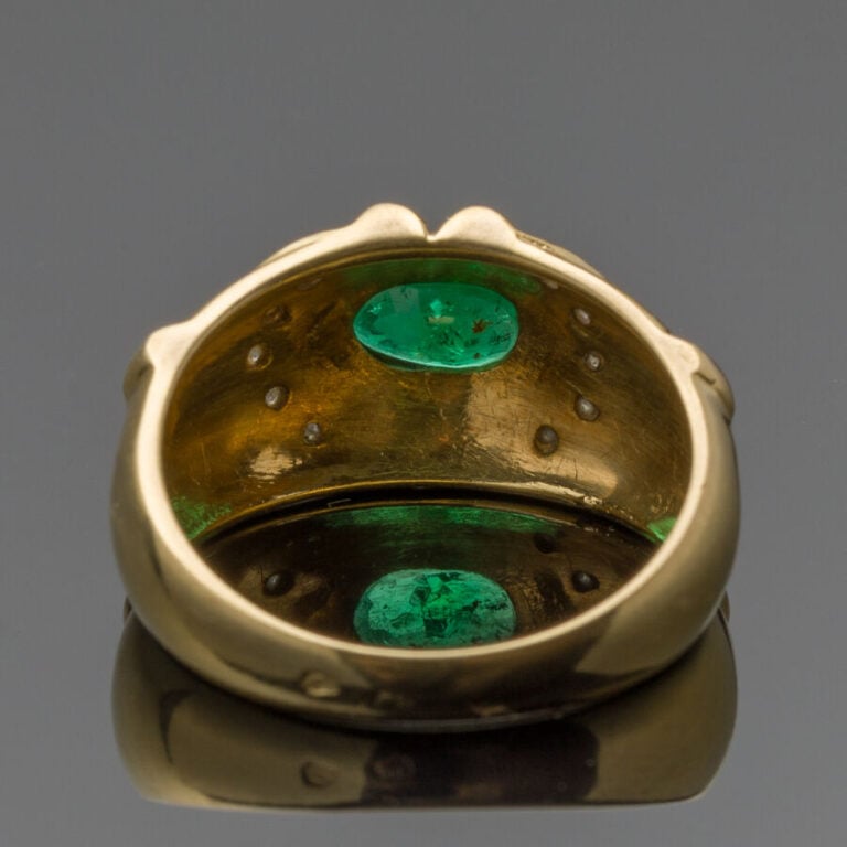 BAGUE en or jaune et or gris (750‰) godronné, serti d'une émeraude ovale soulig…