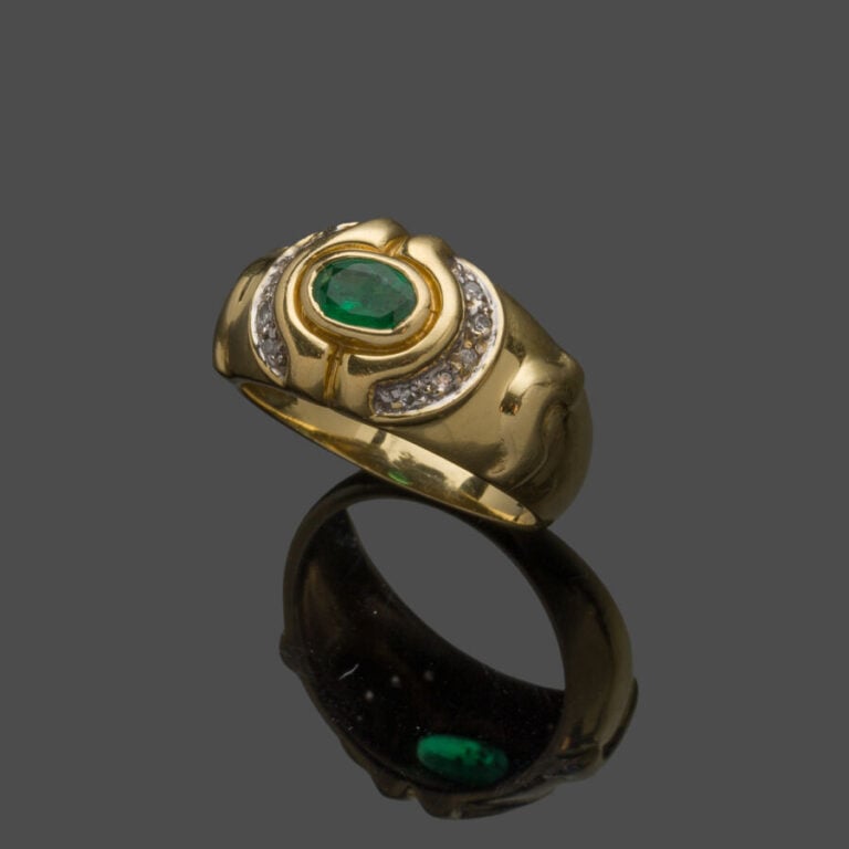 BAGUE en or jaune et or gris (750‰) godronné, serti d'une émeraude ovale soulig…