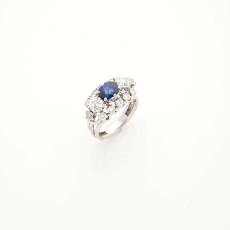 BAGUE en platine (950‰) et or gris (750%) ajouré, serti d'un saphir ovale épaul…