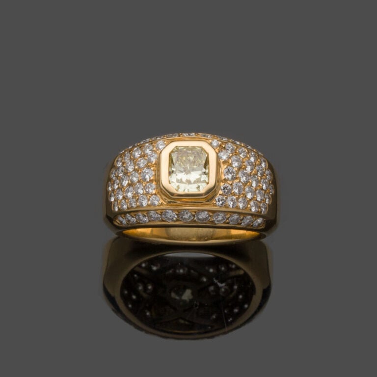 BAGUE "jonc" en or jaune (750‰) serti d'un diamant jaune taille radiant, entour…
