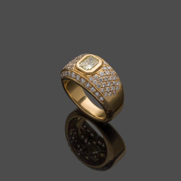 BAGUE "jonc" en or jaune (750‰) serti d'un diamant jaune taille radiant, entour…