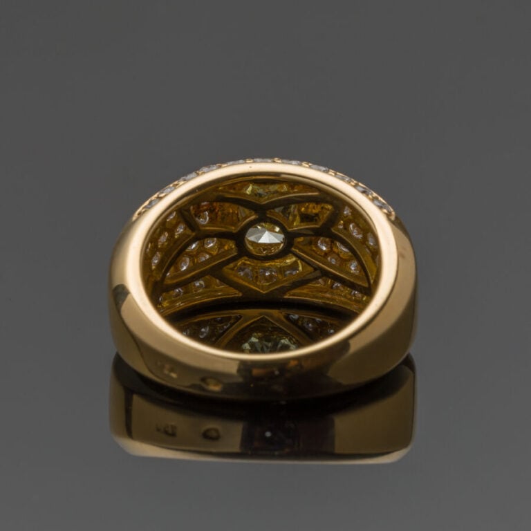 BAGUE "jonc" en or jaune (750‰) serti d'un diamant jaune taille radiant, entour…