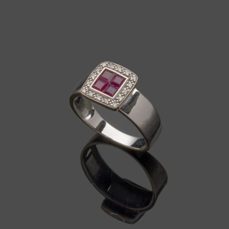 BAGUE jonc plat en or gris (750‰) centrée d'un motif carré serti de quatre rubi…