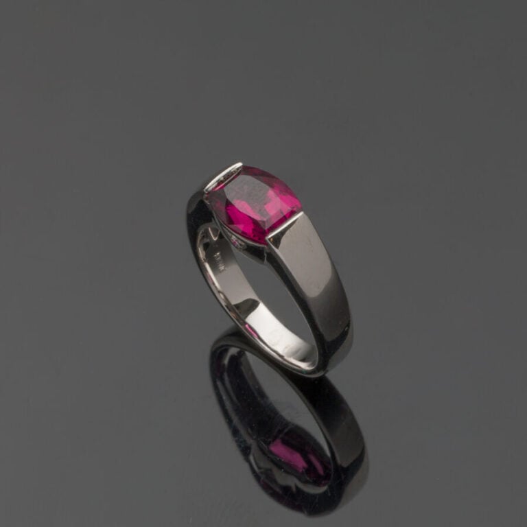 BAGUE jonc plat en or gris (750‰) serti d'un grenat rhodolite de forme "tonneau…