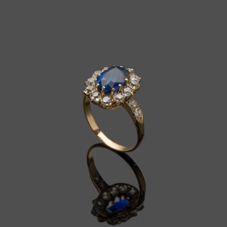 BAGUE "marguerite" en or jaune (750‰) serti d'un saphir de forme coussin, entou…