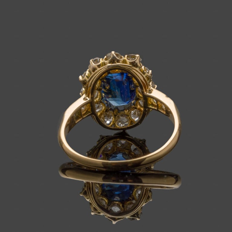 BAGUE "marguerite" en or jaune (750‰) serti d'un saphir de forme coussin, entou…