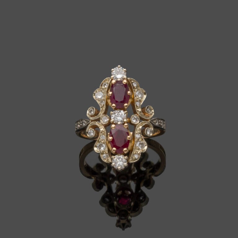 BAGUE "marquise" en or jaune et or gris (750‰) ajouré à motif de volutes, serti…