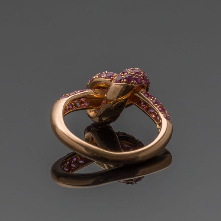 BAGUE "noeud" en or rose (750‰) serti de saphirs roses. Manque une pierre. - Do…