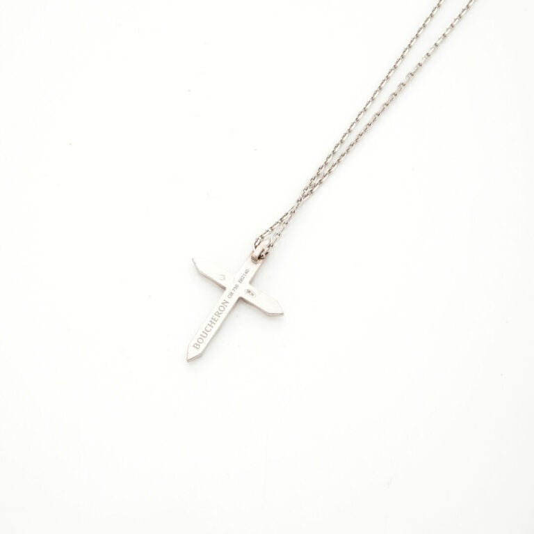 BOUCHERON - PENDENTIF "croix" et sa chainette en or gris (750‰) facetté, serti…