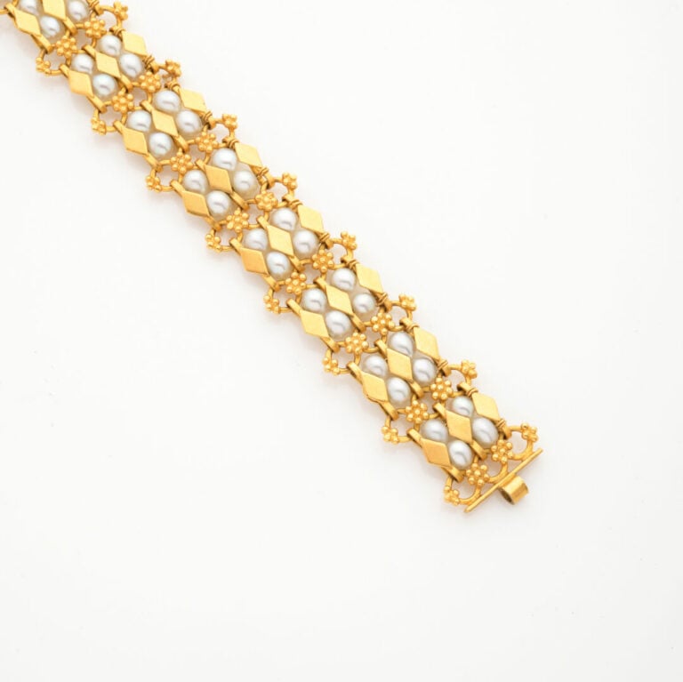 BRACELET articulé en or jaune (750‰) ajouré, orné de perles de culture blanches…