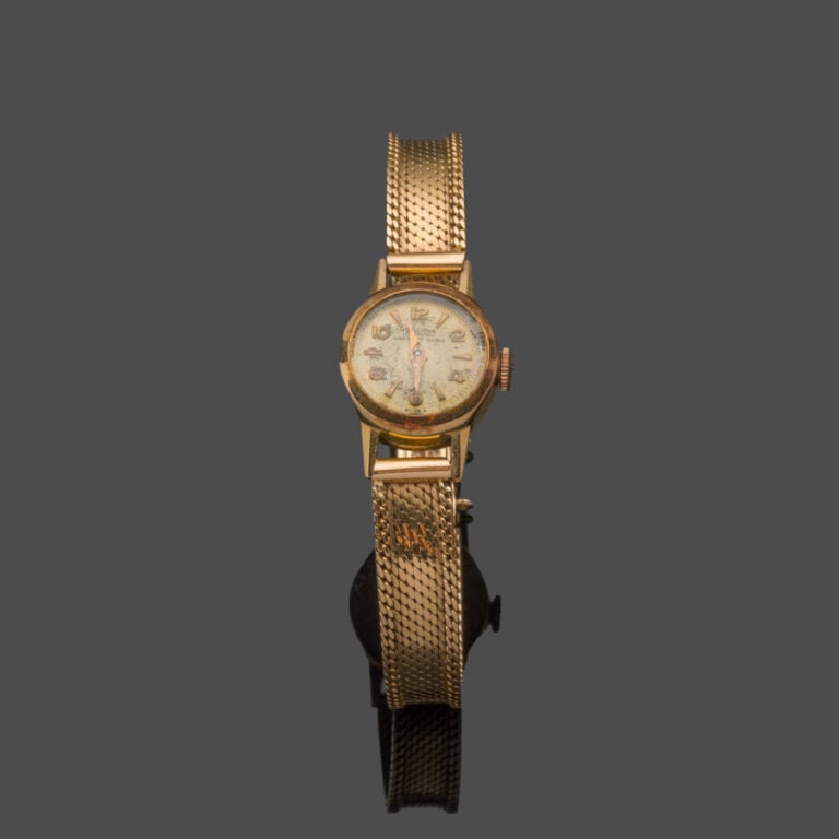 BRACELET MONTRE ronde de dame en or jaune (750‰). Cadran guillocheé doré, index…