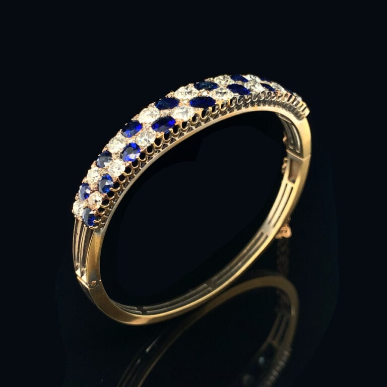 BRACELET rigide ouvrant en or jaune (750‰) ajouré, serti de deux alignements de…