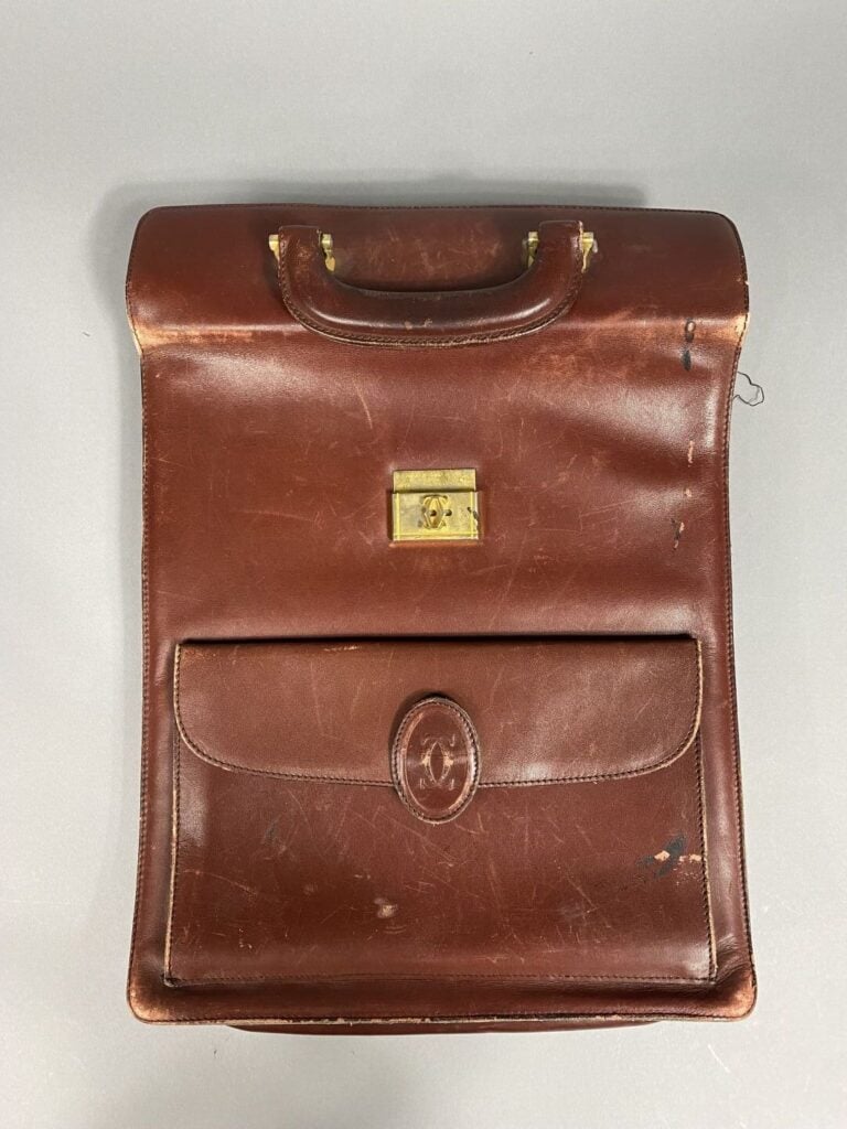 CARTIER - Sacoche cartable portée main en cuir bordeaux, bijouterie dorée , une…