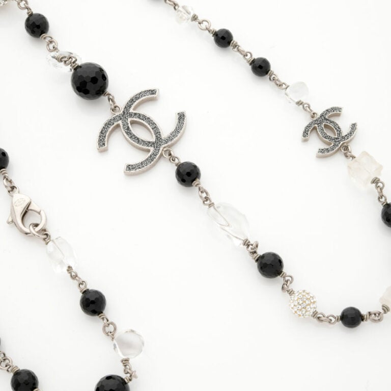 CHANEL - SAUTOIR en métal composé de perles de résine de couleur claire et noir…