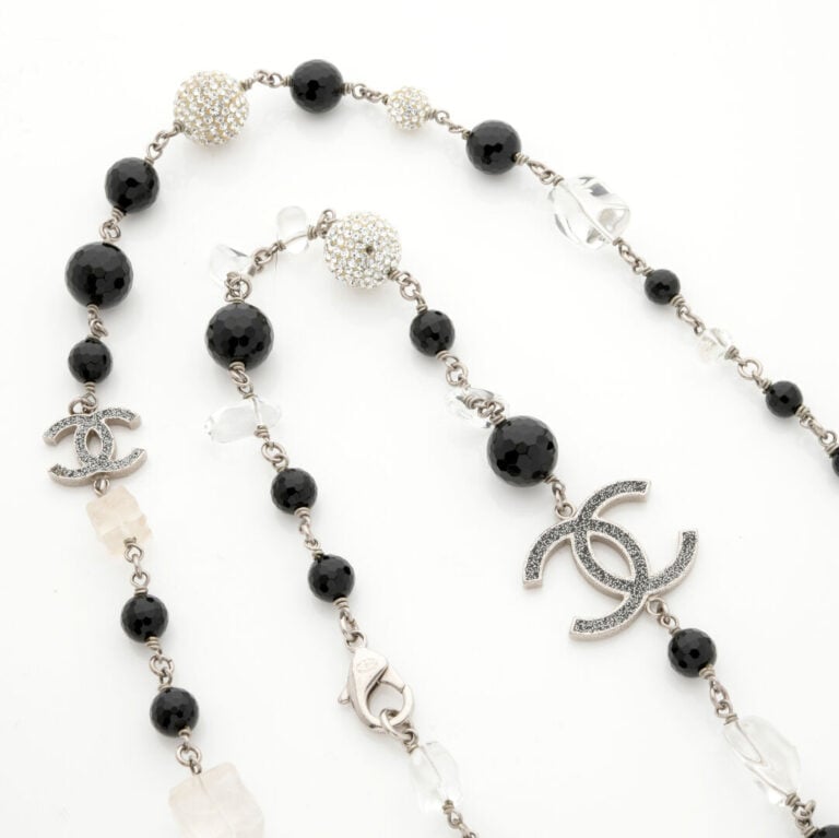 CHANEL - SAUTOIR en métal composé de perles de résine de couleur claire et noir…