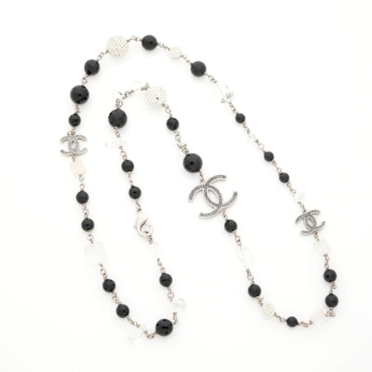 CHANEL - SAUTOIR en métal composé de perles de résine de couleur claire et noir…