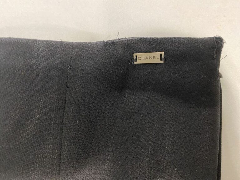 CHANEL - Tailleur pantalon en tissu fluide noir. Boutons en métal argenté siglé…