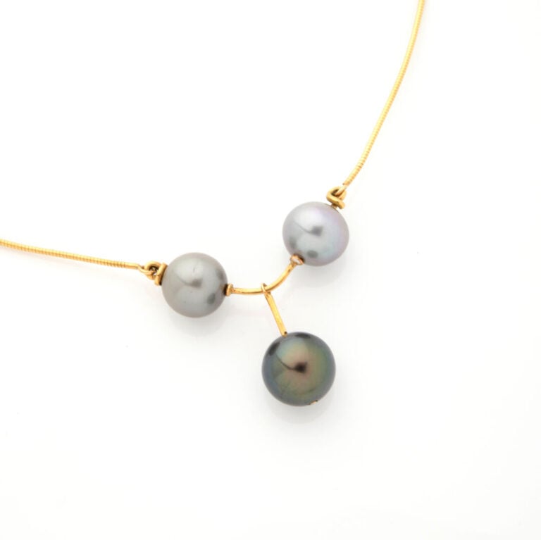 COLLIER " câble" en or jaune (750‰) retenant trois perles de culture grises de…