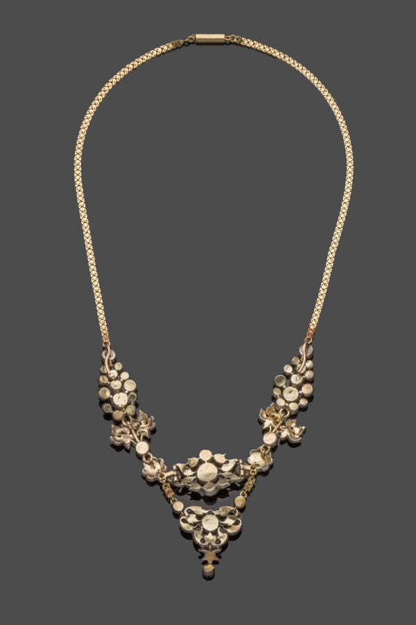 COLLIER "volutes et fleurs" en or jaune (750‰) et argent (min. 800‰) ajouré, se…