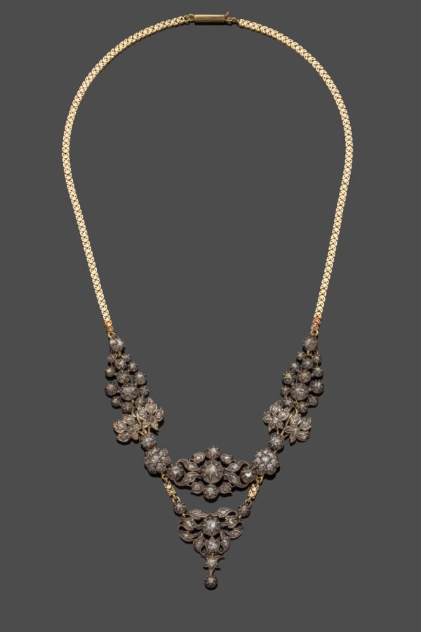 COLLIER "volutes et fleurs" en or jaune (750‰) et argent (min. 800‰) ajouré, se…