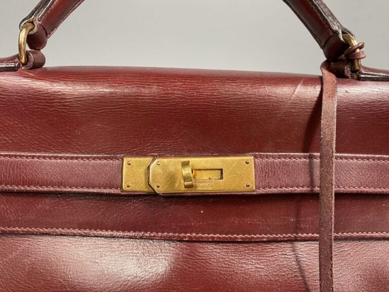 HERMÈS - Année 1959. - Sac Kelly 32 cm en box bordeaux, bijouterie dorée. - Cle…