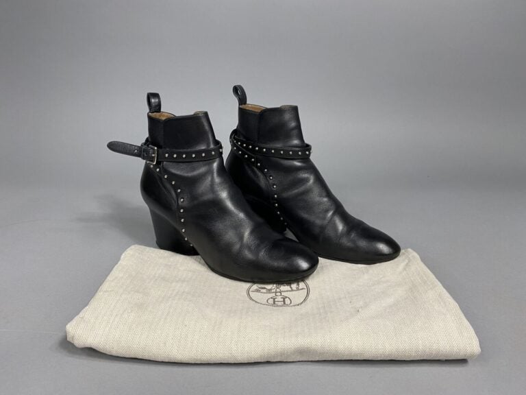 HERMÈS - Bottines en cuir noir, sangle en cuir ornée de clous argenté. - Pointu…