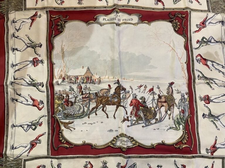 HERMÈS - Carré de soie « Les plaisirs du froid » sur fond beige, bordure rouge…