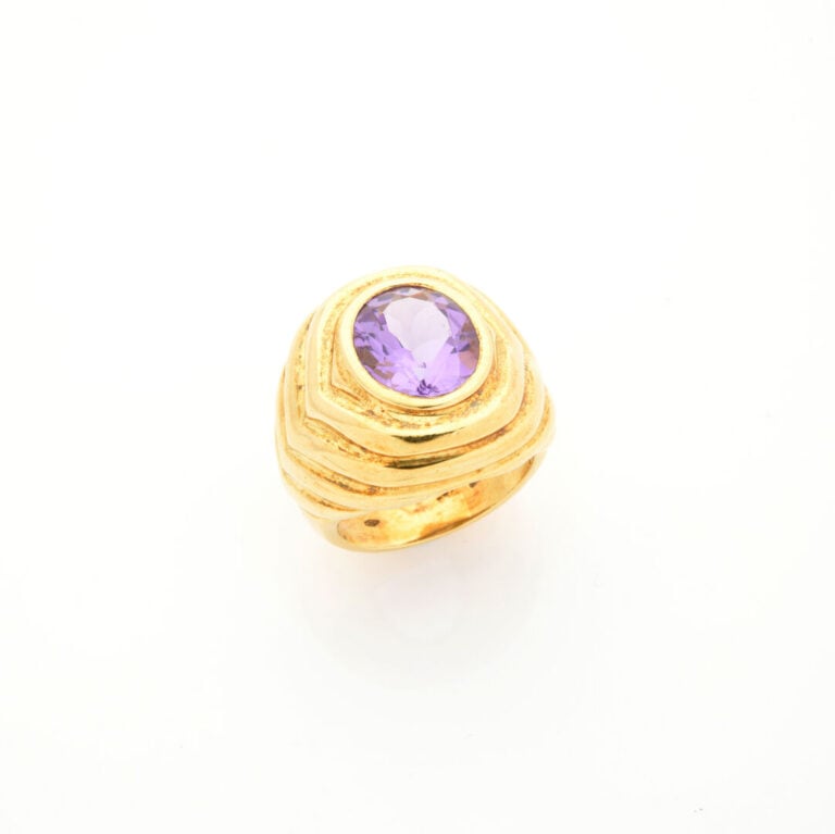 Importante BAGUE en or jaune (750‰) godronné, serti d'une améthyste en serti cl…