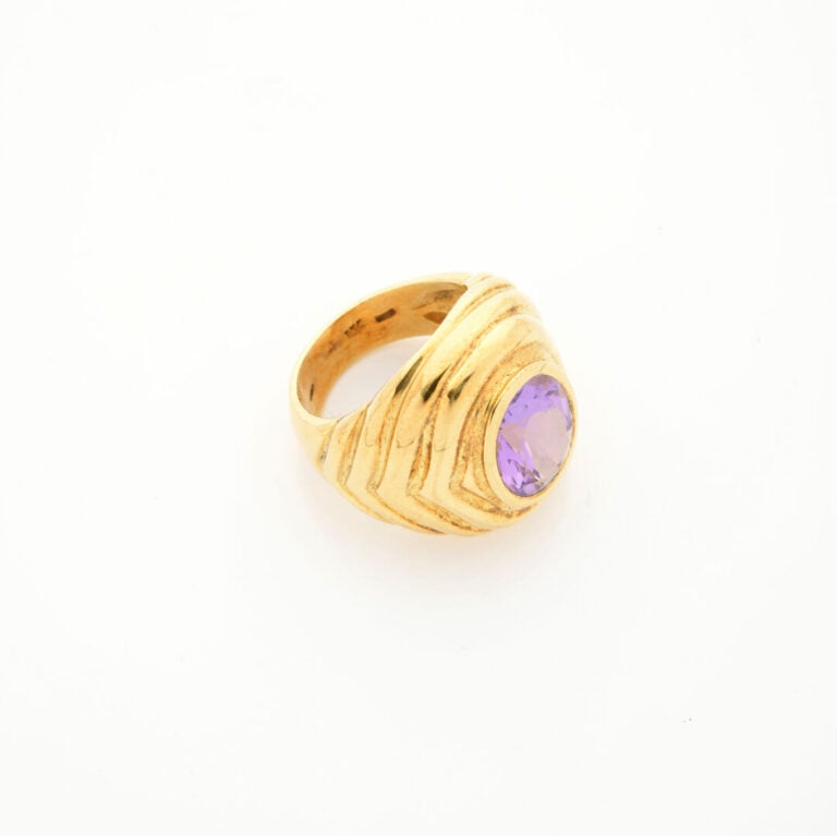 Importante BAGUE en or jaune (750‰) godronné, serti d'une améthyste en serti cl…