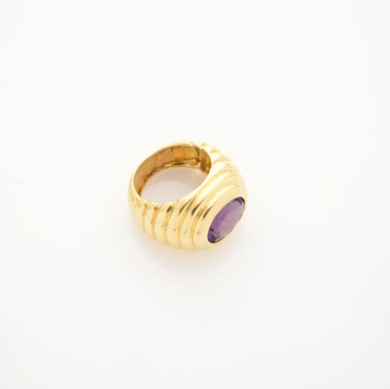 Importante BAGUE en or jaune (750‰) godronné, surmonté d'une améthyste ovale. -…