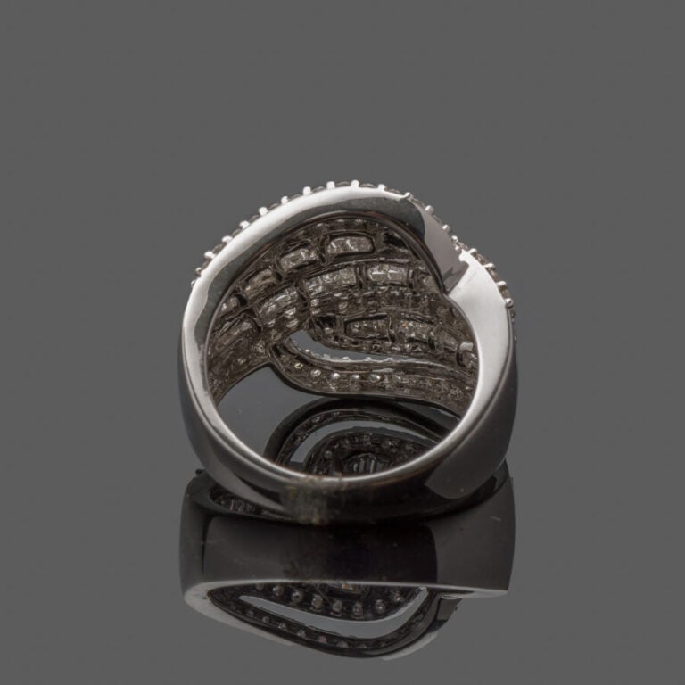 Importante BAGUE « volutes » en or gris (750‰) ajouré, serti de six alignements…