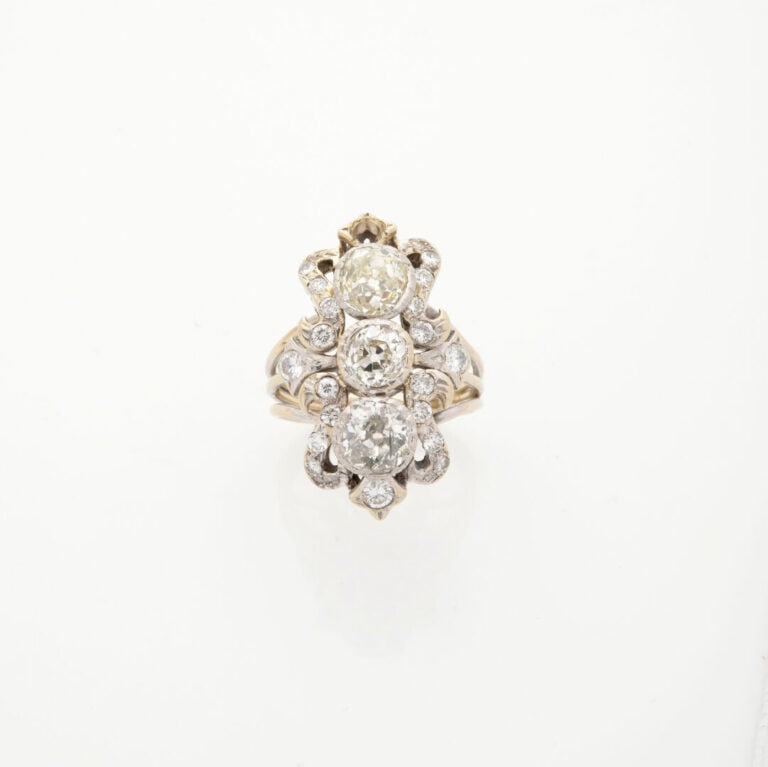 Importante BAGUE "volutes" en or gris (750‰) ajouré, serti de trois diamants ta…