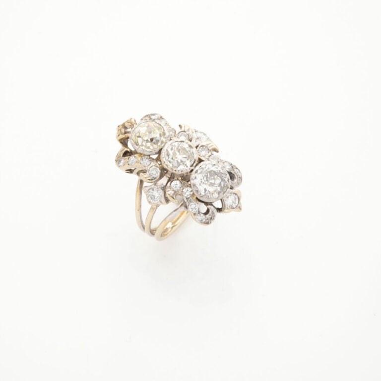 Importante BAGUE "volutes" en or gris (750‰) ajouré, serti de trois diamants ta…