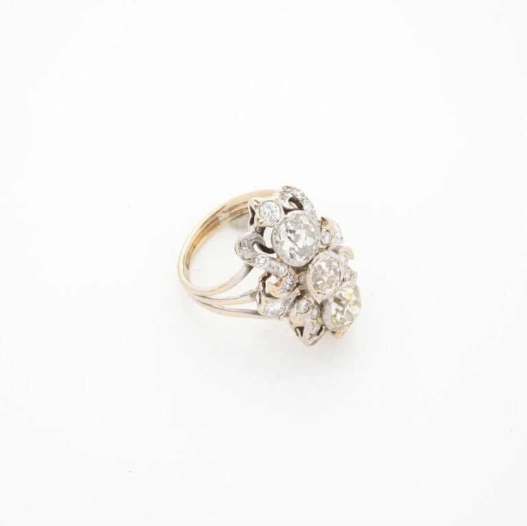 Importante BAGUE "volutes" en or gris (750‰) ajouré, serti de trois diamants ta…