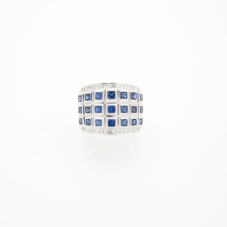 Large BAGUE en or gris (750‰) serti de saphirs calibrés soulignés de diamants t…