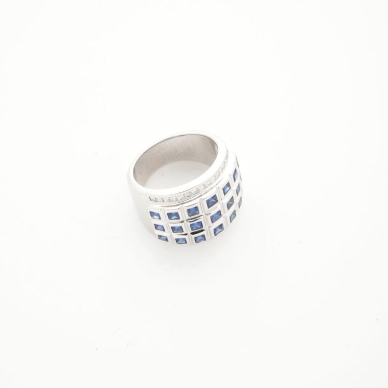 Large BAGUE en or gris (750‰) serti de saphirs calibrés soulignés de diamants t…