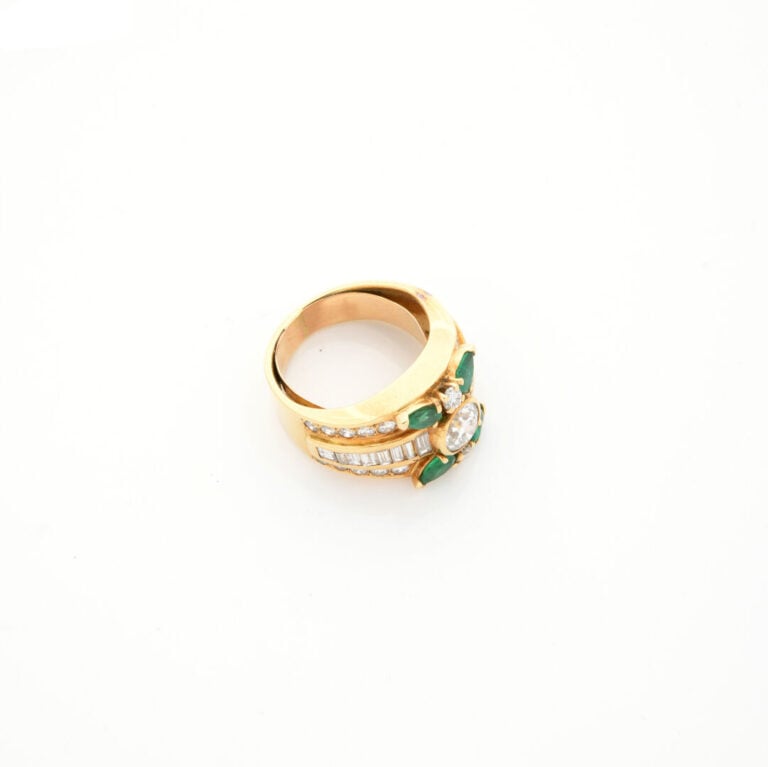 Large BAGUE en or jaune (750‰) centré d'un diamant taille brillant épaulé de di…