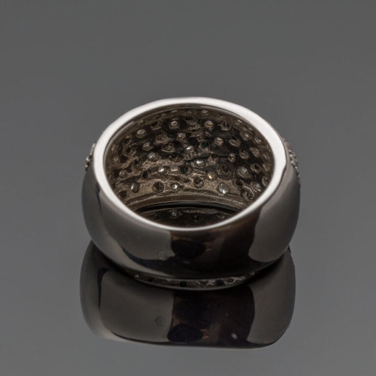 Large BAGUE légèrement bombée en or gris et or noirci (750‰) serti de seize ali…