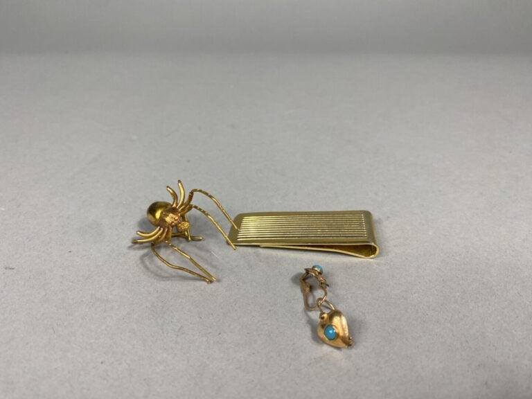 Lot en métal doré comprenant une pince à billets à décor rainurré, une broche a…
