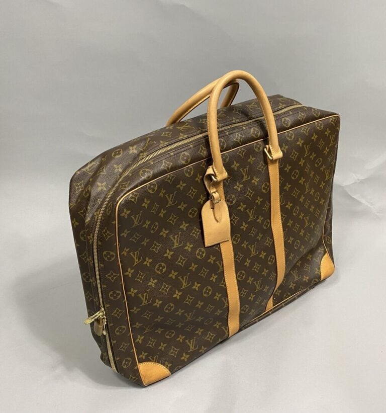 LOUIS VUITTON - Valise Sirius 55 cm en toile monogram, parements en cuir nature…