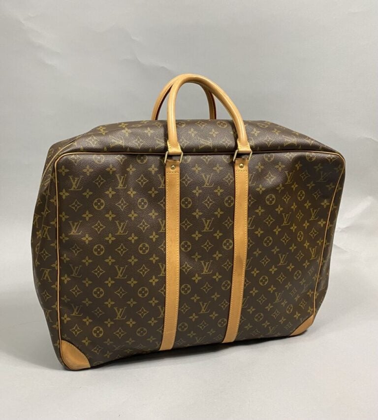 LOUIS VUITTON - Valise Sirius 55 cm en toile monogram, parements en cuir nature…