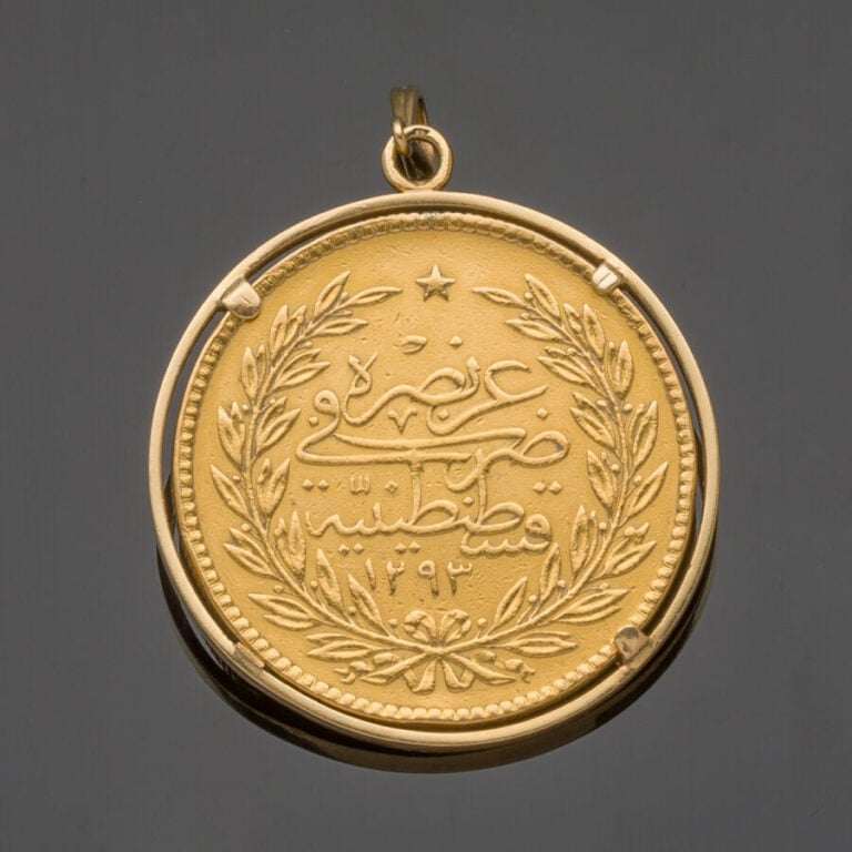 PENDENTIF circulaire en or jaune (750‰) ajouré serti d'une pièce de monnaie ott…