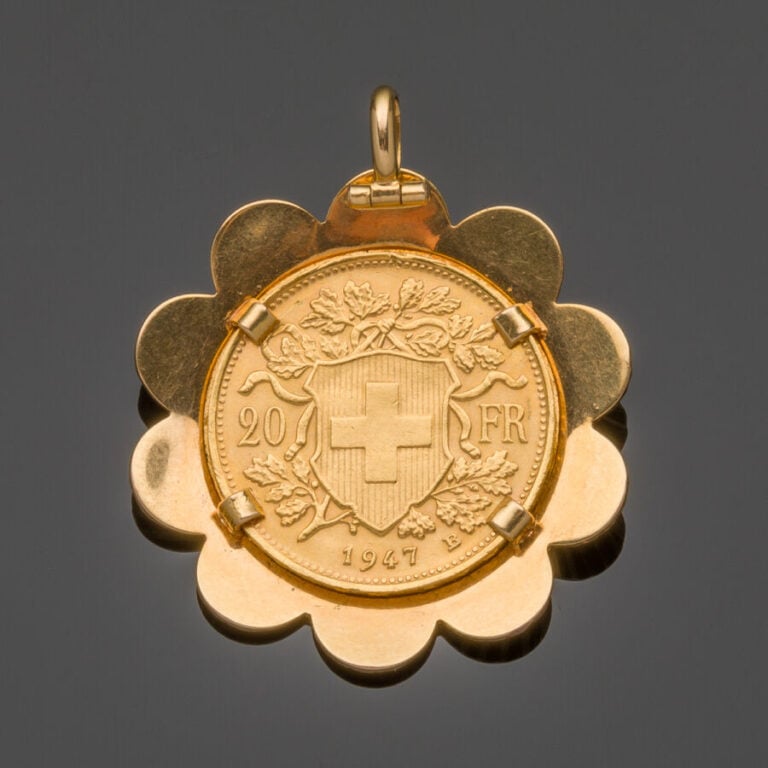 PENDENTIF "fleur" en or jaune (750‰) découpé et guilloché, retenant une pièce d…