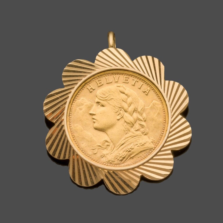 PENDENTIF "fleur" en or jaune (750‰) découpé et guilloché, retenant une pièce d…