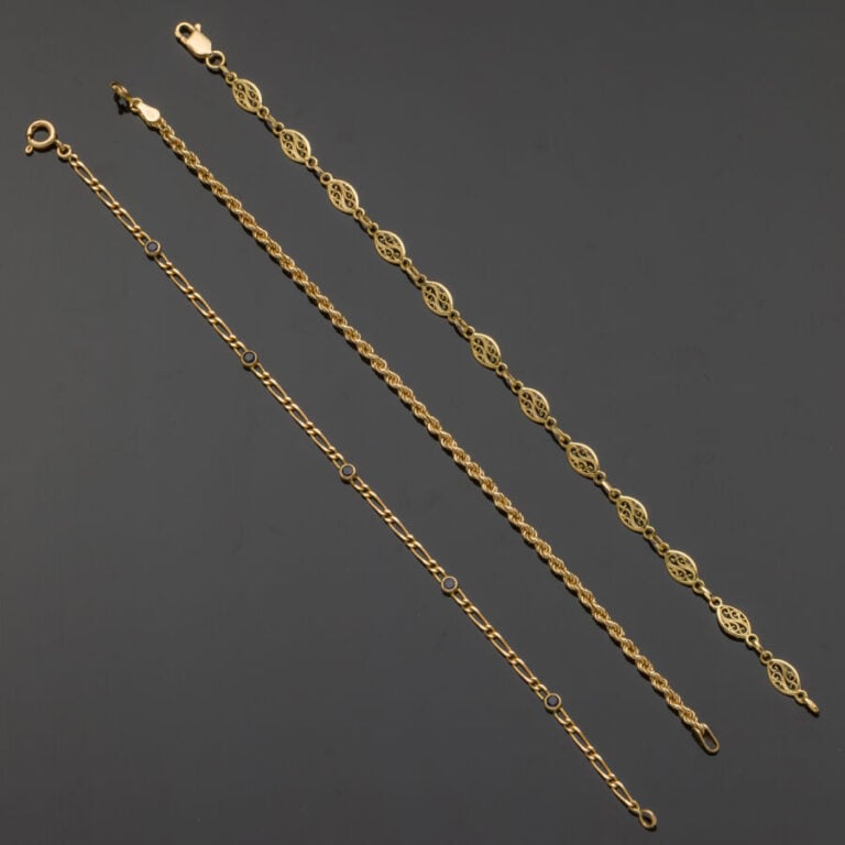 Trois BRACELETS en or jaune (750‰) ciselé et ajouré à mailles diverses, l'un se…