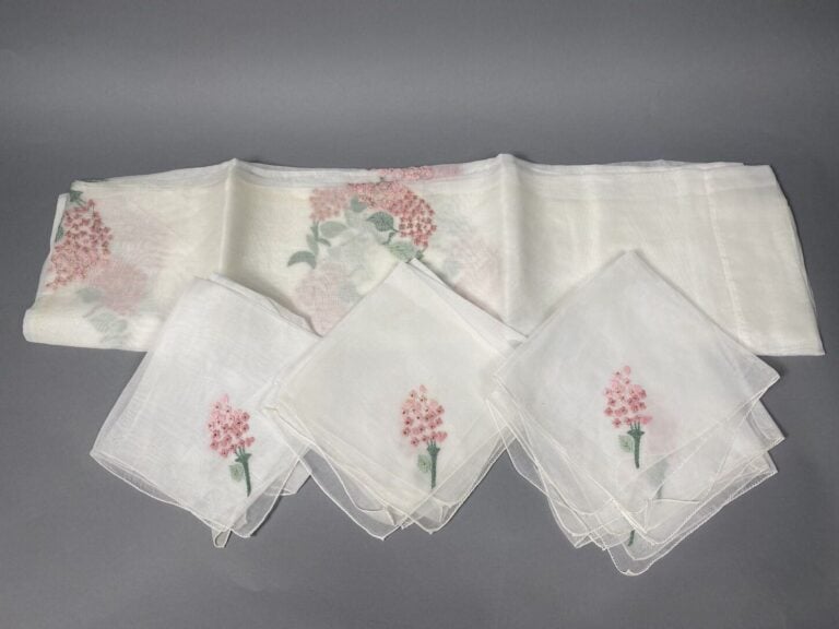 Ensemble de 2 nappes blanches à décor brodé de motifs floraux rehaussés de lure…