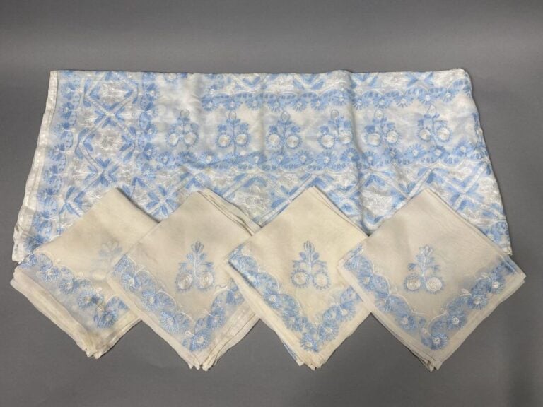 Grande nappe en organdi blanc à décor brodé de motifs floraux stylisés bleu cie…