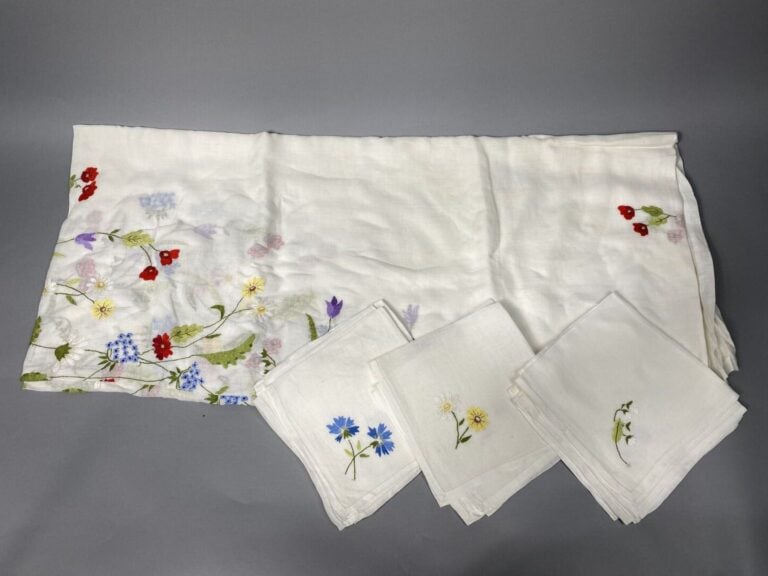 Nappe en étamine de coton blanc à décor brodé de fleurs des champs polychromes.…