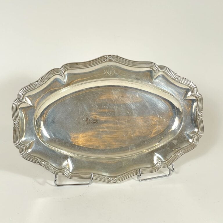 PUIFORCAT. PLAT ovale en argent à contours soulignés de filets forts et rubans…